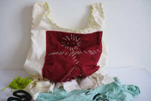SAC T-SHIRT <br> Les enfants créent un sac à partir de vieux T-shirts. Ils découpent, nouent et décorent le tissus
avec des tampons et de la peinture. Cet atelier est l’occasion d’expliquer aux enfants l’intérêt
de recycler.